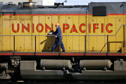 A maintenance worker walks past a locomotive in the Union Pacific Railroad fueling yard in north Denver, Oct. 18, 2006.