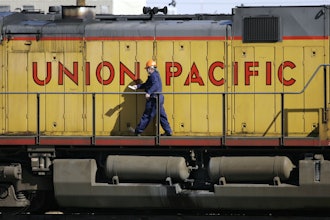 A maintenance worker walks past a locomotive in the Union Pacific Railroad fueling yard in north Denver, Oct. 18, 2006.