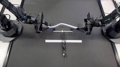 TactileAloha physical AI robot holding velcro.