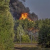 Smoke and flames rise following powerful explosions after several rail cars loaded with liquefied gas caught fire in the suburbs of Vilnius, Lithuania, Wednesday, Sept. 10, 2025.