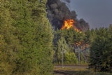 Smoke and flames rise following powerful explosions after several rail cars loaded with liquefied gas caught fire in the suburbs of Vilnius, Lithuania, Wednesday, Sept. 10, 2025.