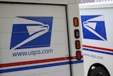 U.S. Postal Service delivery vehicles are parked outside a post office in Boys Town, Neb., Aug. 18, 2020.