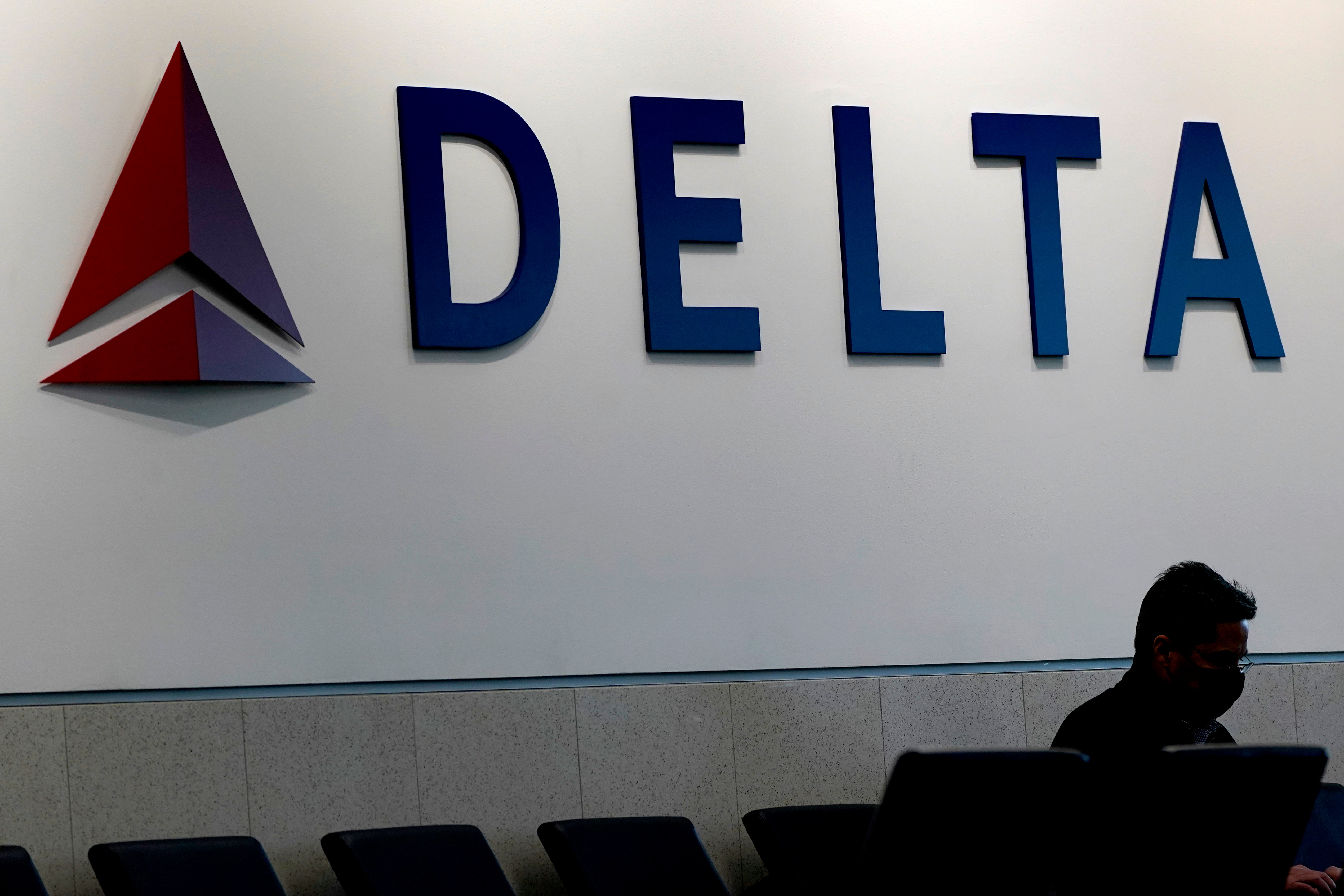 A man waits for a Delta Airlines flight at Hartsfield-Jackson International Airport in Atlanta on Jan. 7, 2022. ()