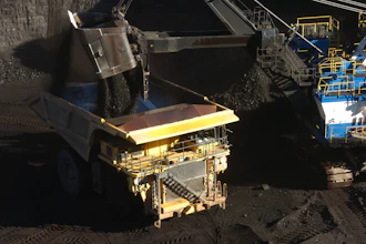 Large mining excavator loading coal at industrial mining site with machinery