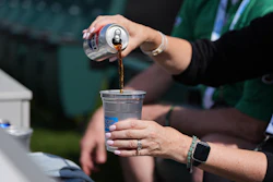 A fan pours a drink into an aluminum cup during an NFL football game in Philadelphia, Sunday, Sept. 21, 2025.