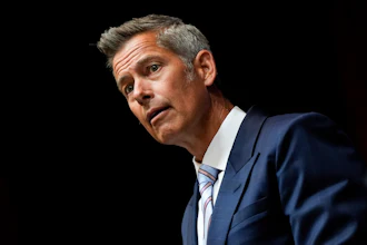 Middle-aged professional in navy suit looking thoughtful with slightly tilted head