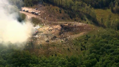 Smoke fills the air as debris covers the ground and vehicles after a powerful blast ripped through a military explosives manufacturing plant in Hickman County, Tenn., on Friday, Oct. 10, 2025.