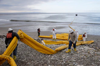 Workers prepare an oil containment boom at Refugio State Beach, north of Goleta, Calif., May 21, 2015.