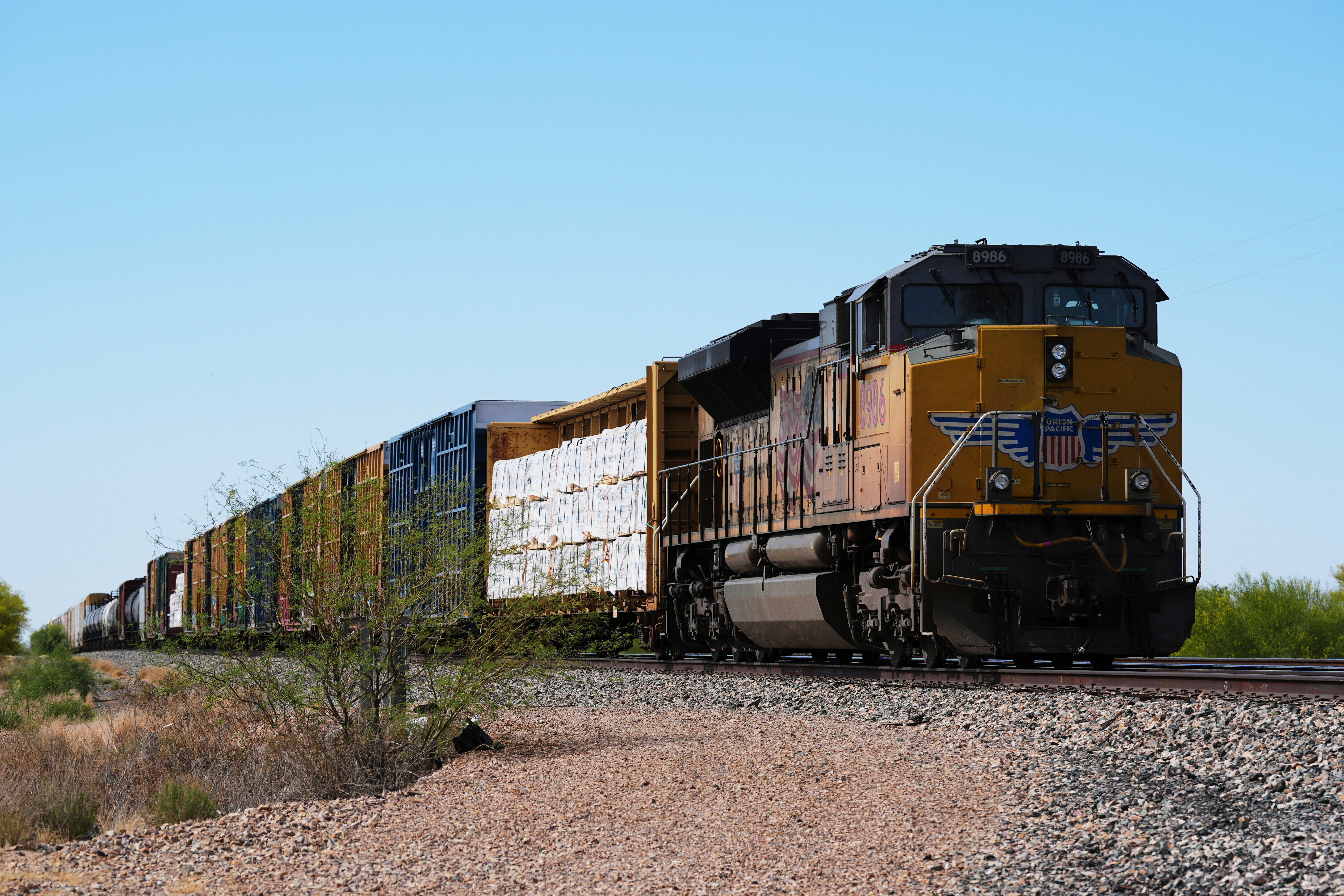 A Union Pacific freight train idles on the track as it waits to continue moving, Thursday, April 17, 2025, in Red Rock, Ariz.