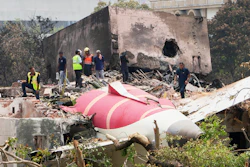 Officials inspect the site of Air India plane crash on the roof of a building in Ahmedabad, India, June 13, 2025.