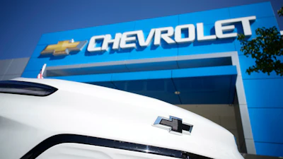 The company logo shines off the nose of an unsold 2022 Bolt electric vehicle on display in front of a Chevrolet dealership Sunday, Sept. 12, 2021, in Englewood, Colo.