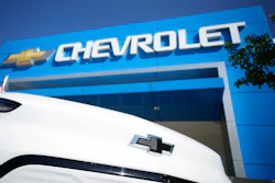 The company logo shines off the nose of an unsold 2022 Bolt electric vehicle on display in front of a Chevrolet dealership Sunday, Sept. 12, 2021, in Englewood, Colo.