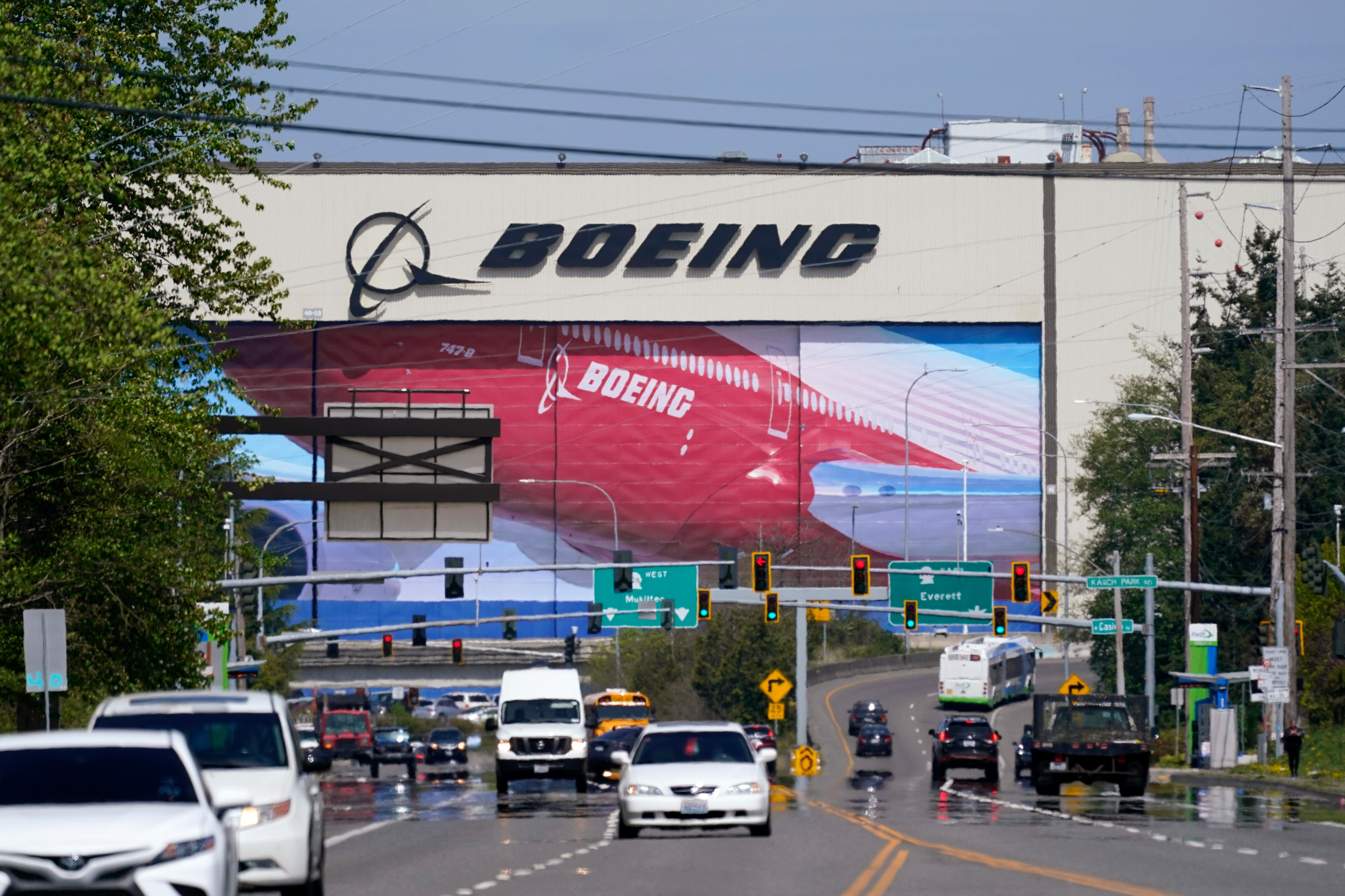 Traffic drives in view of a Boeing Co. production plant, where images of jets decorate the hangar doors on April 23, 2021, in Everett, Wash.