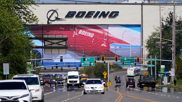 Traffic drives in view of a Boeing Co. production plant, where images of jets decorate the hangar doors on April 23, 2021, in Everett, Wash.