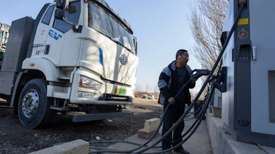 A driver charges his electric truck at a charging station on the outskirts of Beijing, on Nov. 14, 2025.