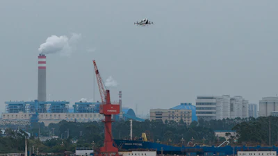 The EHang eVTOL EH126-S takes to the sky over a port in Guangzhou in southern China's Guangdong province on Monday, Nov. 3, 2025.