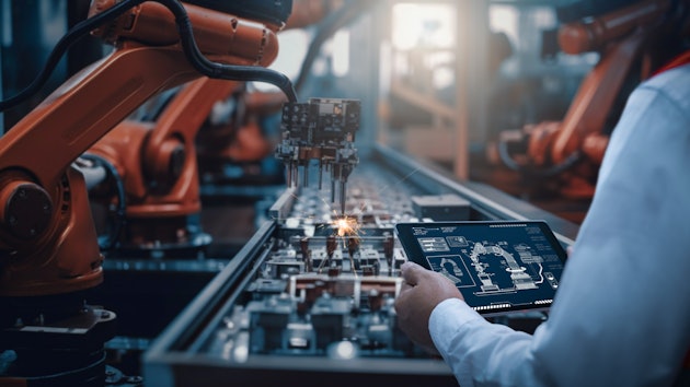 Industrial robotic arms operating on a manufacturing assembly line.