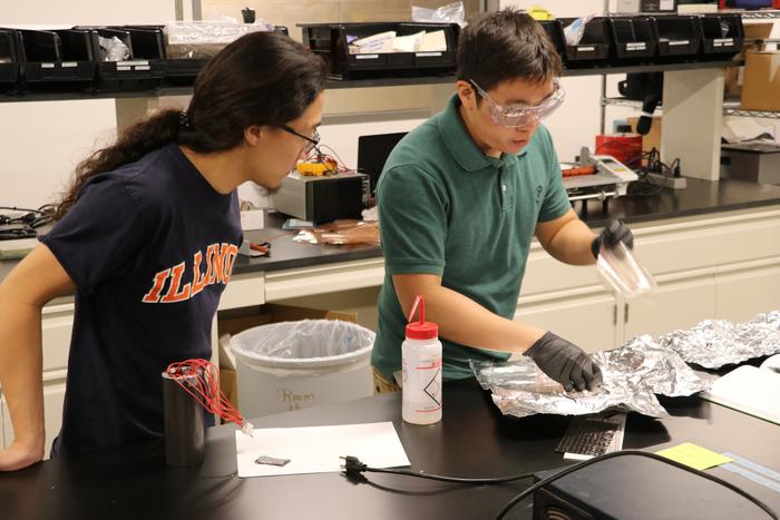 Aerospace undergrad Alex Kuehnle observes PhD student Ivan Wu in the composites laboratory at the University of Illinois Urbana-Champaign.