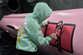 A painter writes 'Dana 1' referring to Czech nuclear physicist Dana Drabova on the side of a Flamingo cruise missile, which was paid by a crowdfunding campaign of a Czech organization, Weapons to Ukraine, at the Fire Point factory at an undisclosed location in Ukraine, Sunday, Nov. 16, 2025.