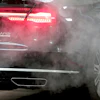 A luxury Audi car is surrounded by exhaust gases as it is parked with a running engine in front of the Chancellery in Berlin, Germany, Wednesday, Nov. 20, 2019.