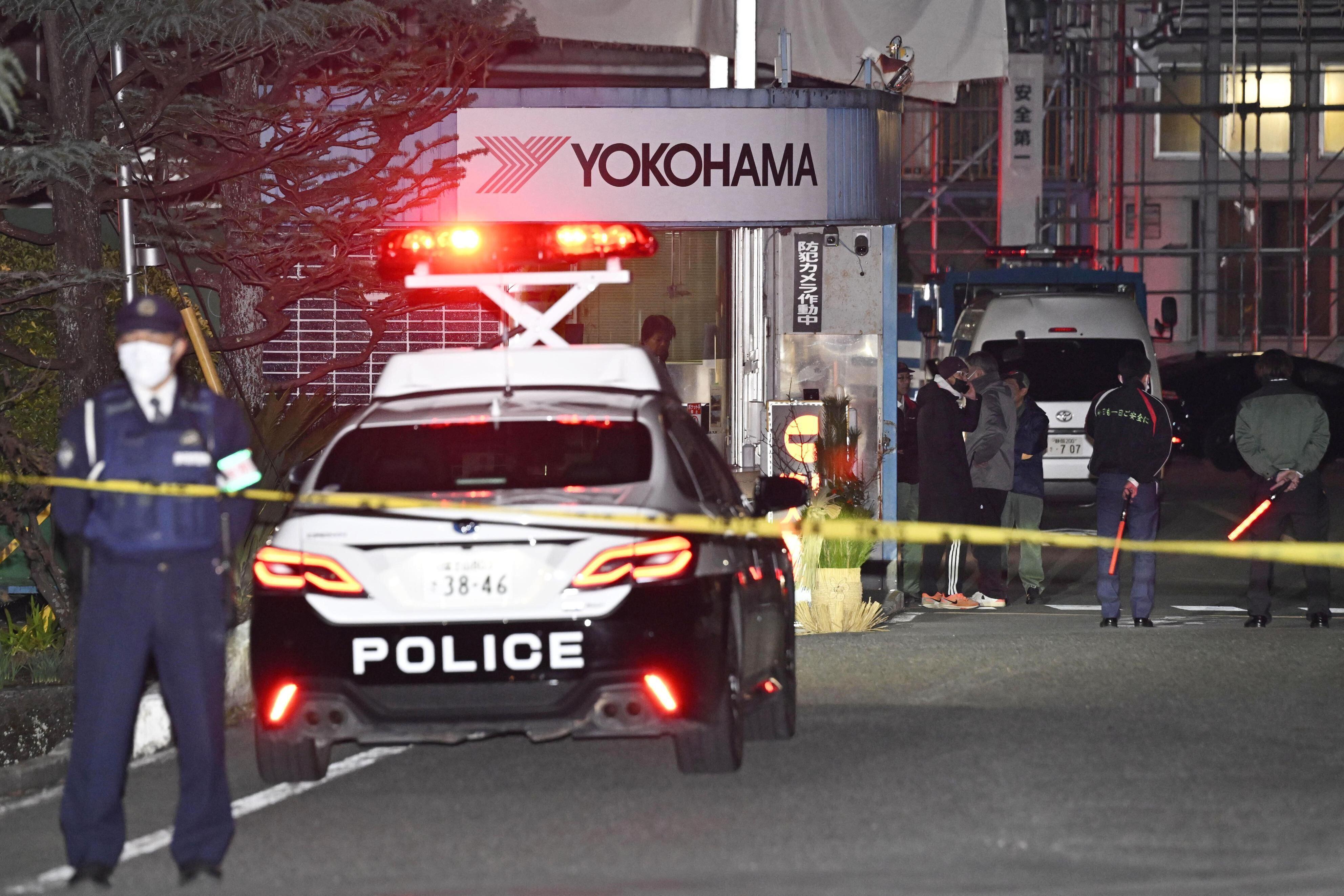 Police officers stand guard at the scene of a stabbing at the Yokohama Rubber Company in Mishima, west of Tokyo, Friday, Dec. 26, 2025.