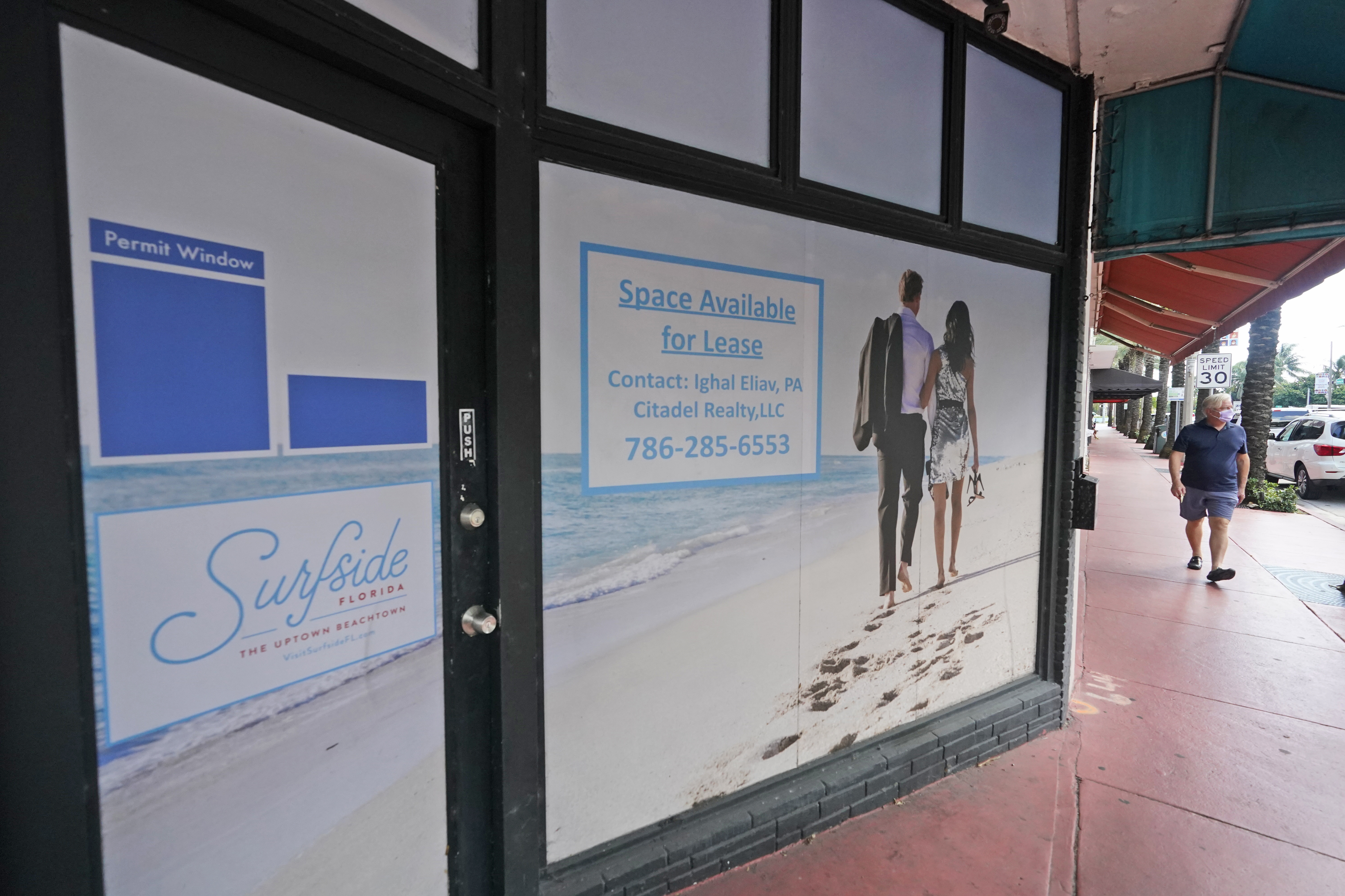 A pedestrian walks past an empty business available for lease, Oct. 12, 2020, Surfside, Fla.