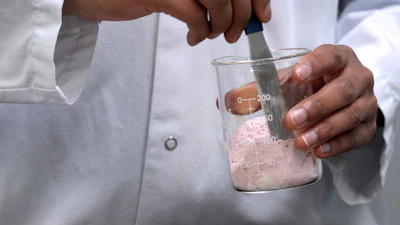 Applications Scientist Anuj Bag mixes coloring with flour at Sensient Technologies Corp., a color additive manufacturing company, April 2, 2025, in St. Louis.