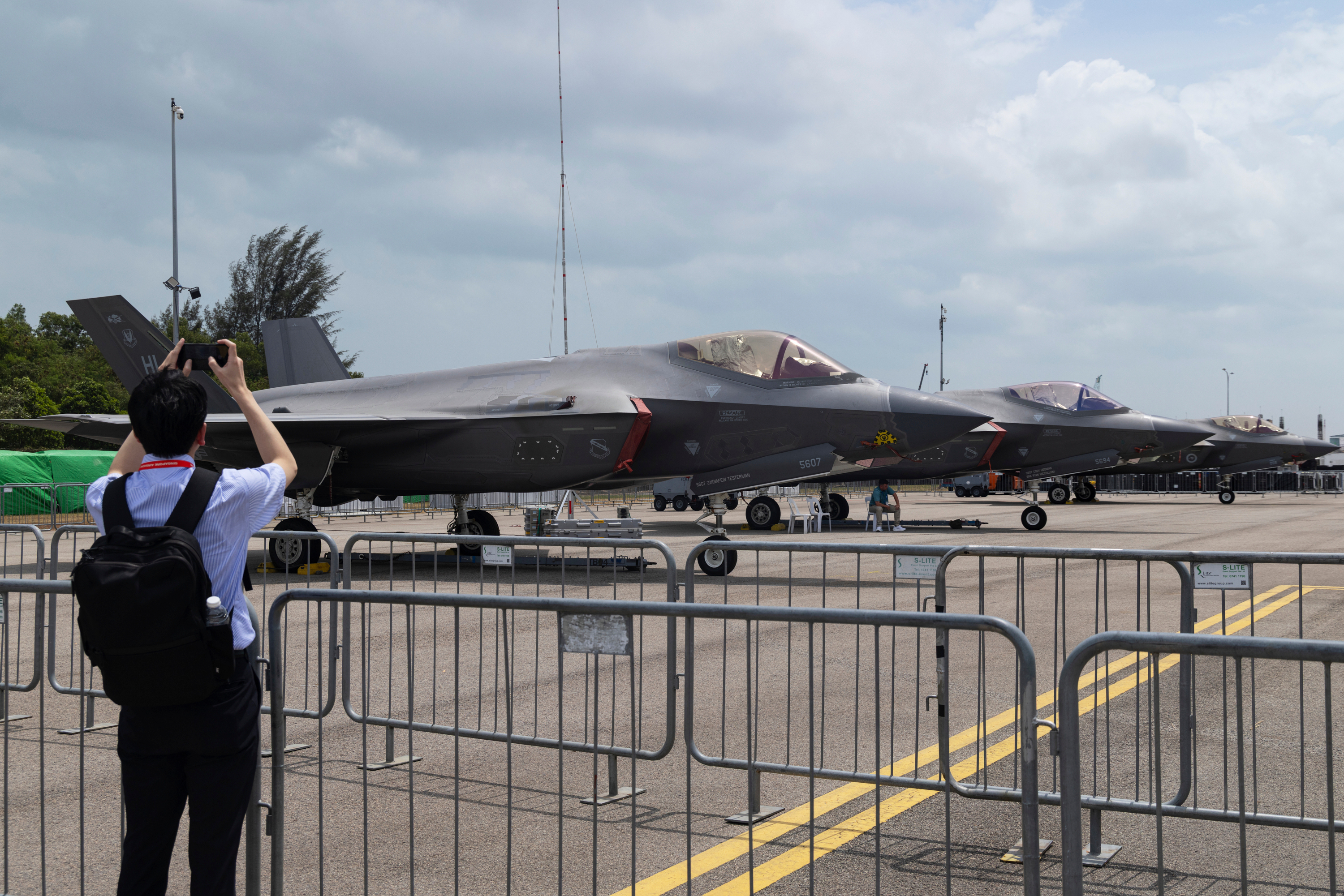 A man takes a picture of a row of F-35 Lightning II fighter jets during the Singapore Air Show on Thursday, Feb. 5, 2026.