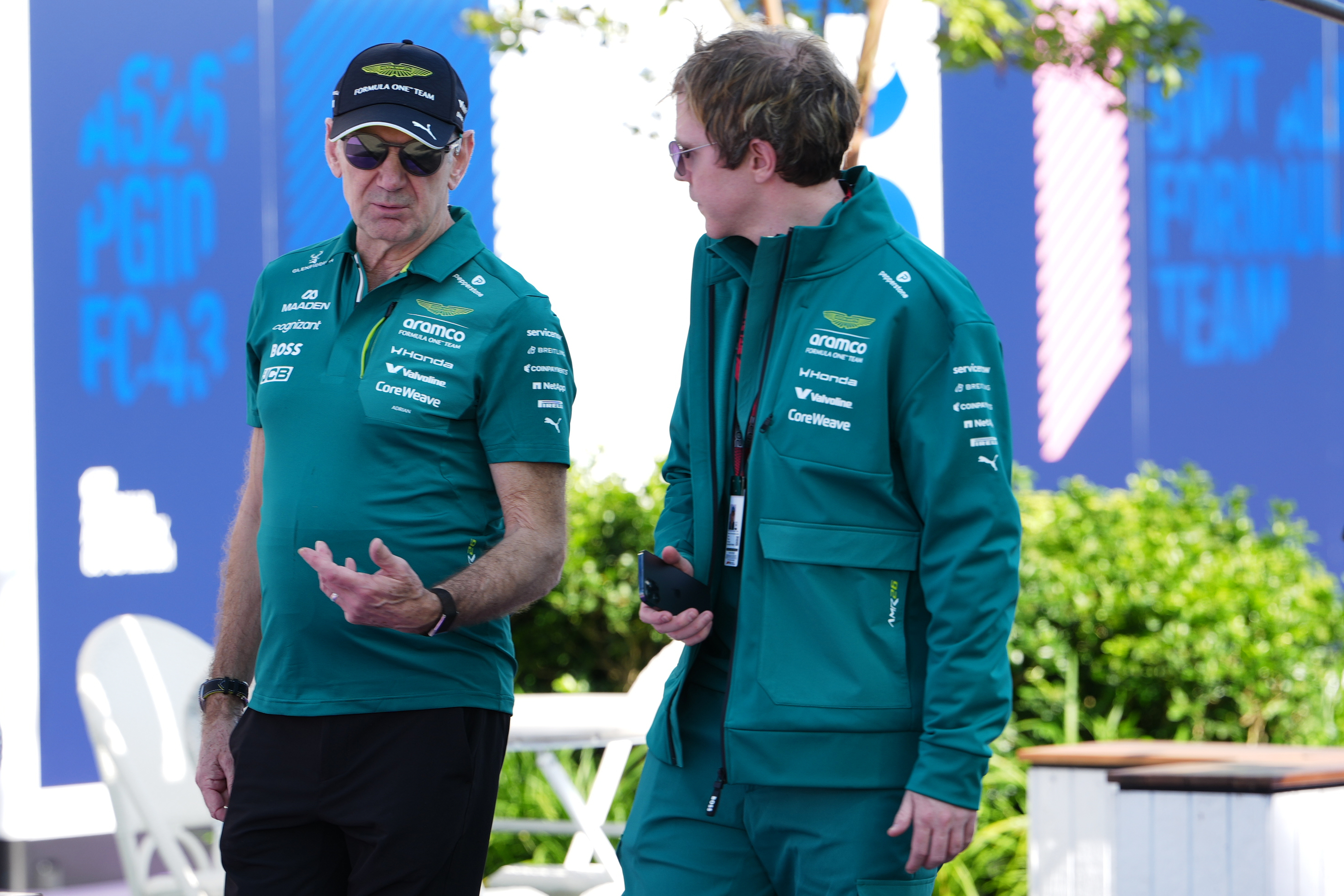 Aston Martin team principal Adrian Newey, left, talks with a team member as he arrives at the track ahead of the Australian Formula One Grand Prix at Albert Park, in Melbourne, Australia, Thursday, March 5, 2026.