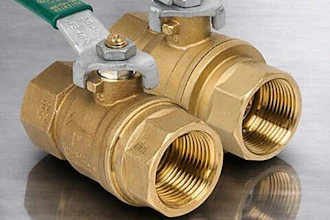 Brass ball valves with colored handles and threaded connections displayed on reflective surface