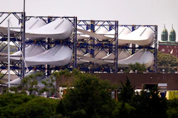 Giant wind turbine blades for the Vineyard Winds project are stacked on racks in the harbor, July 11, 2023, in New Bedford, Mass.