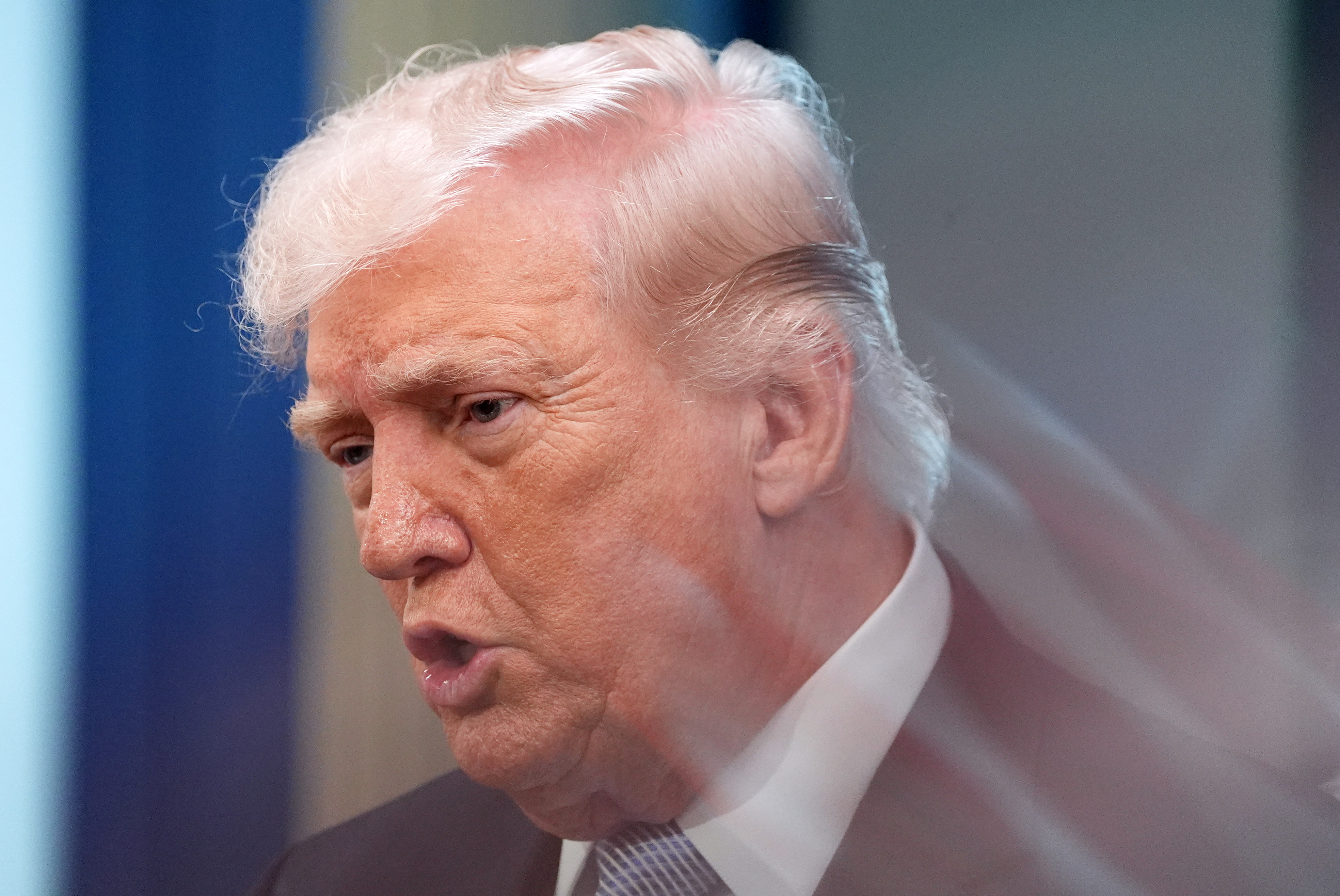 A zoom lens and slow shutter speed technique shows President Donald Trump speaking with reporters in the James Brady Press Briefing Room at the White House, April 6, 2026.