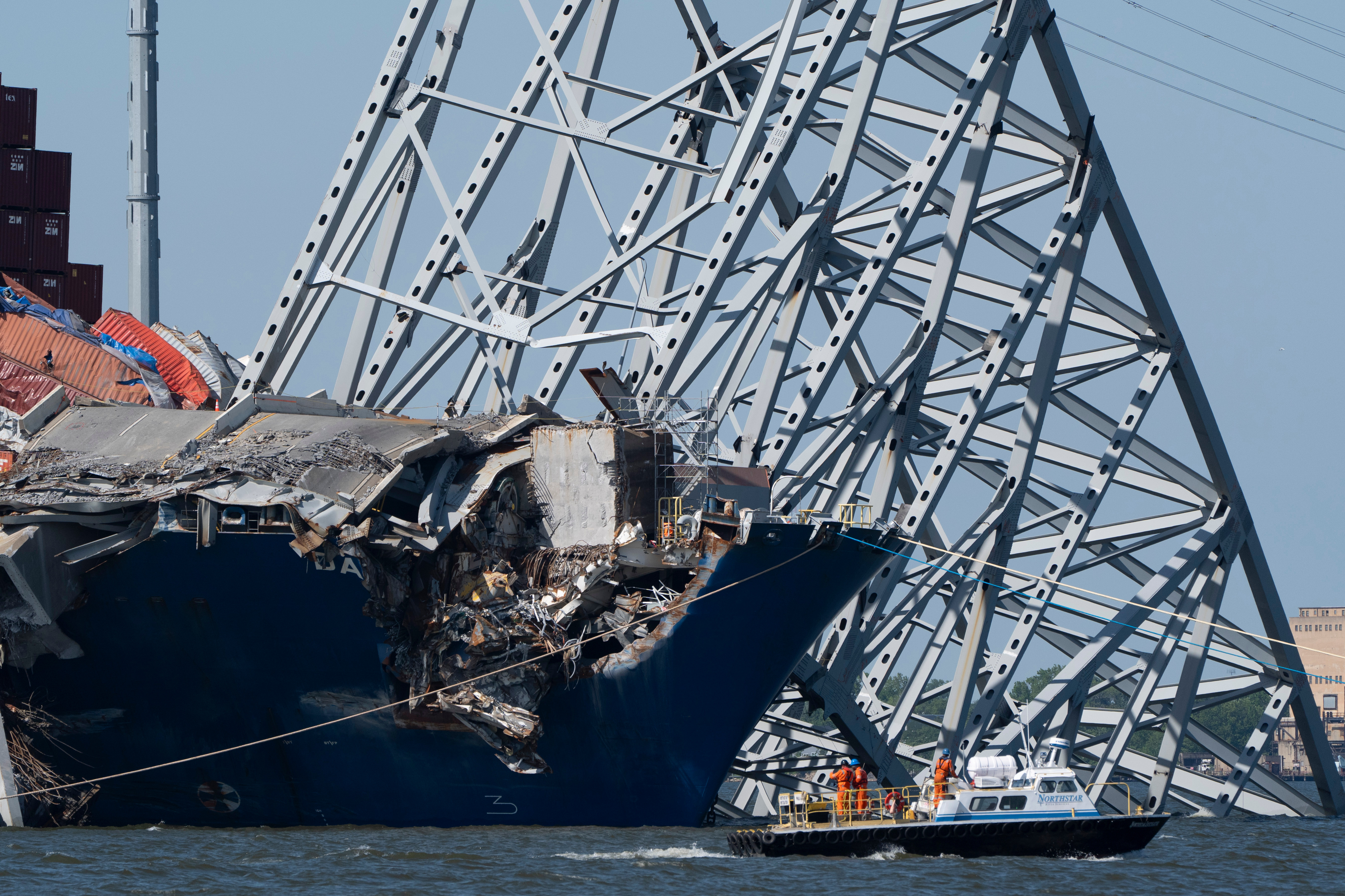 A boat moves past the bow of the container ship Dali prior to the detonation of explosive charges to bring down sections of the collapsed Francis Scott Key Bridge resting on the Dali, May 13, 2024, in Baltimore.