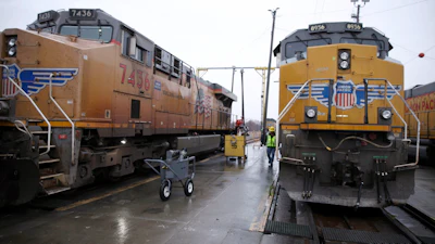 A Union Pacific worker walks between two locomotives in a railyard in Council Bluffs, Iowa, Dec. 15, 2023.