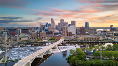 The Minneapolis, Minnesota, city skyline over the river at dusk.