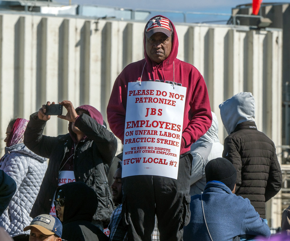 Workers from the JBS Beef Plant protest across the road from the plant on March 16, 2026 in Greeley, Colo.