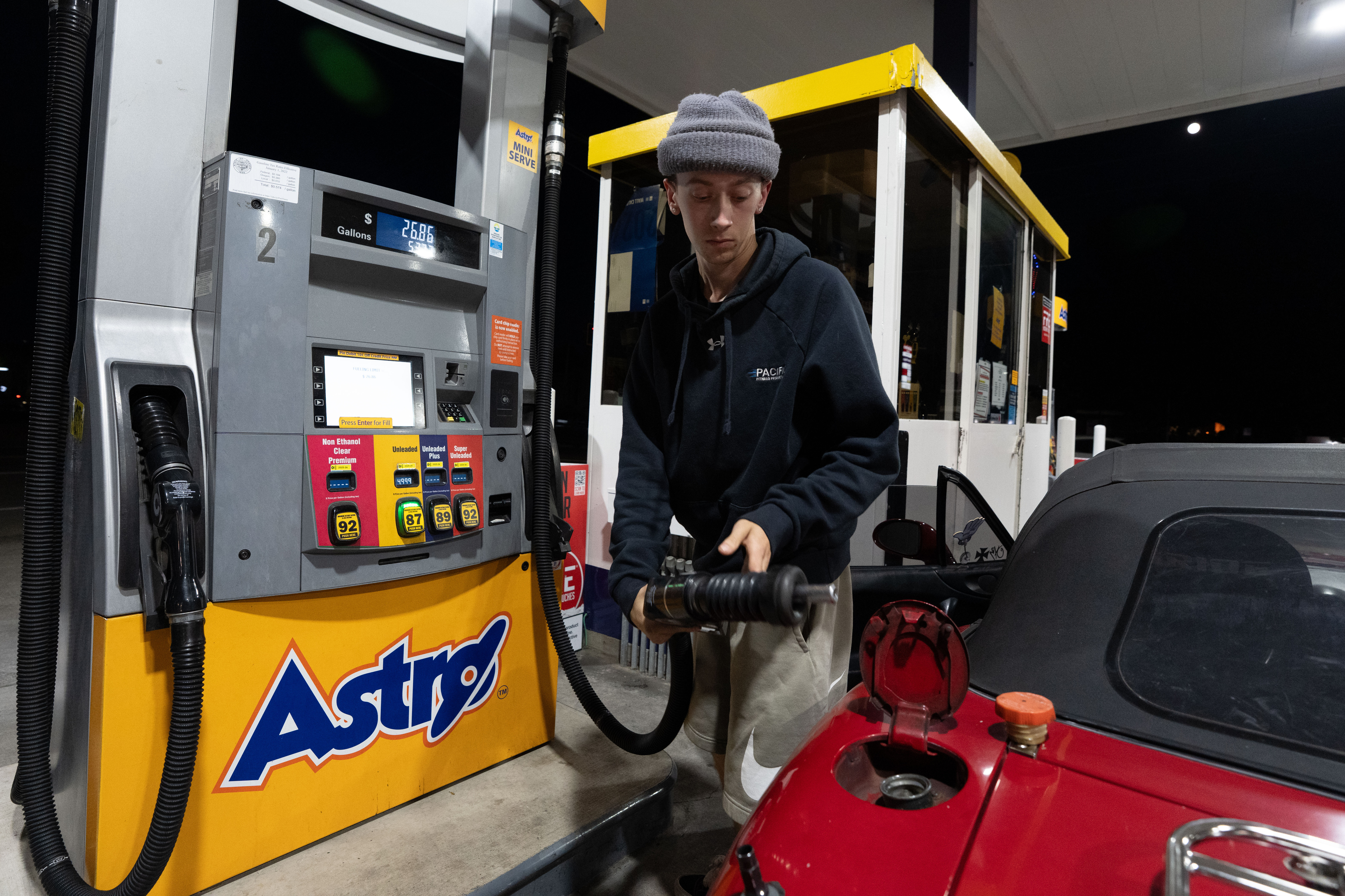 Luciano V. replaces the fuel nozzel after filling the tank of their 1999 Mazda Miata at an Astro gas station on Wednesday, April 29, 2026, in Portland, Ore.