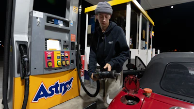 Luciano V. replaces the fuel nozzel after filling the tank of their 1999 Mazda Miata at an Astro gas station on Wednesday, April 29, 2026, in Portland, Ore.