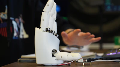 Massachusetts Institute of Technology mechanical engineering graduate student Dian Li demonstrates how an ultrasound wristband can help a robotic hand mimic full hand motions in Cambridge, Mass, on Tuesday, April 14, 2026.