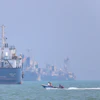 A motorboat passes anchored vessels in the Strait of Hormuz off Bandar Abbas, Iran, June 11, 2026.