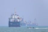 A motorboat passes anchored vessels in the Strait of Hormuz off Bandar Abbas, Iran, June 11, 2026.