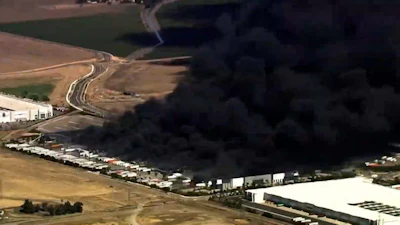 This image from aerial video shows black smoke pouring into the sky from a fire at a medical equipment warehouse in Tracy, Calif., Thursday, June 11, 2026.