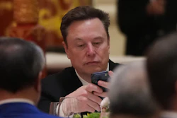 Elon Musk uses his phone during a state dinner for President Donald Trump and Chinese President Xi Jinping at the Great Hall of the People on Thursday May 14, 2026, in Beijing.