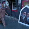 Pedestrians walk past a poster showing slain Iranian Supreme Leader Ayatollah Ali Khamenei, left, and the late revolutionary founder Ayatollah Khomeini, Islamic Revolution square, Tehran, June 14, 2026.