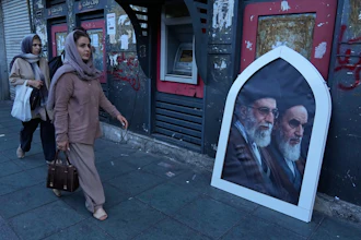 Pedestrians walk past a poster showing slain Iranian Supreme Leader Ayatollah Ali Khamenei, left, and the late revolutionary founder Ayatollah Khomeini, Islamic Revolution square, Tehran, June 14, 2026.