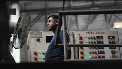 A worker stands in front of a fan on a hot day at Vinit Fabrics in Palsana near Surat, India, Tuesday, May 26, 2026.
