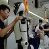 Workers assemble robot at the LY iTech Beijing Super Factory for Embodied Artificial Intelligence during a media tour in the Beijing E-Town on the outskirts of Beijing on May 29, 2026.