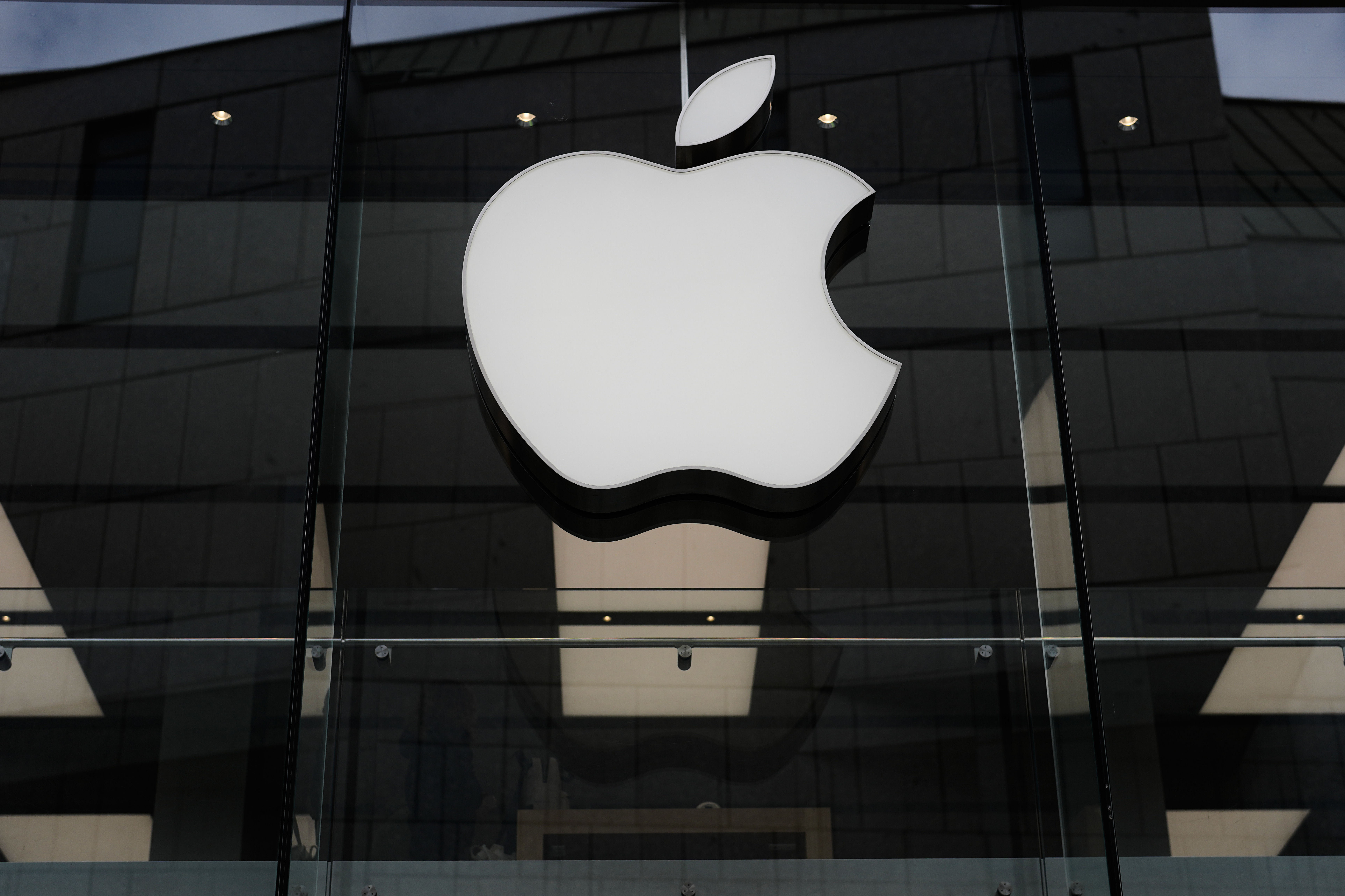 The Apple logo is illuminated at a store in Munich, April 2, 2026.