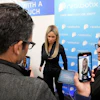 A Realbotix humanoid robot, center, speaks with attendees at a Realbotix booth during the CES tech show Jan. 8, 2025, in Las Vegas.