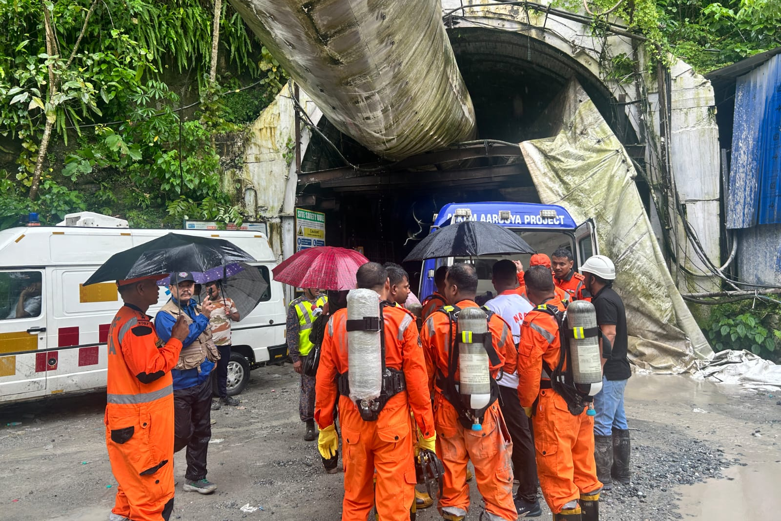 Members of the rescue team carry oxygen cylinders outside the entrance to an under-construction tunnel at a hydropower project in Samardung village, about 40 kilometers (25 miles) from Gangtok, India, Tuesday, July 21, 2026.